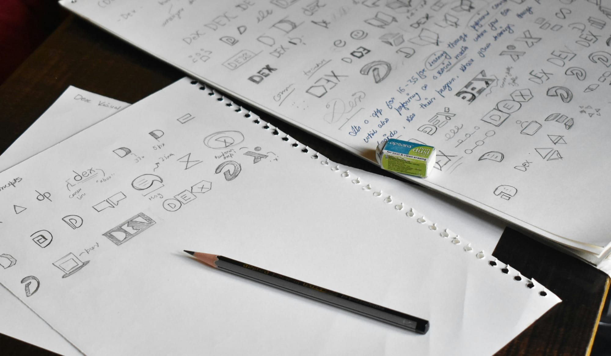 Pencil sketches of logo ideas in a notebook